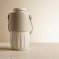 AURA Nomade portable diffuser in off-white ceramic with cream leather sleeve and carry strap