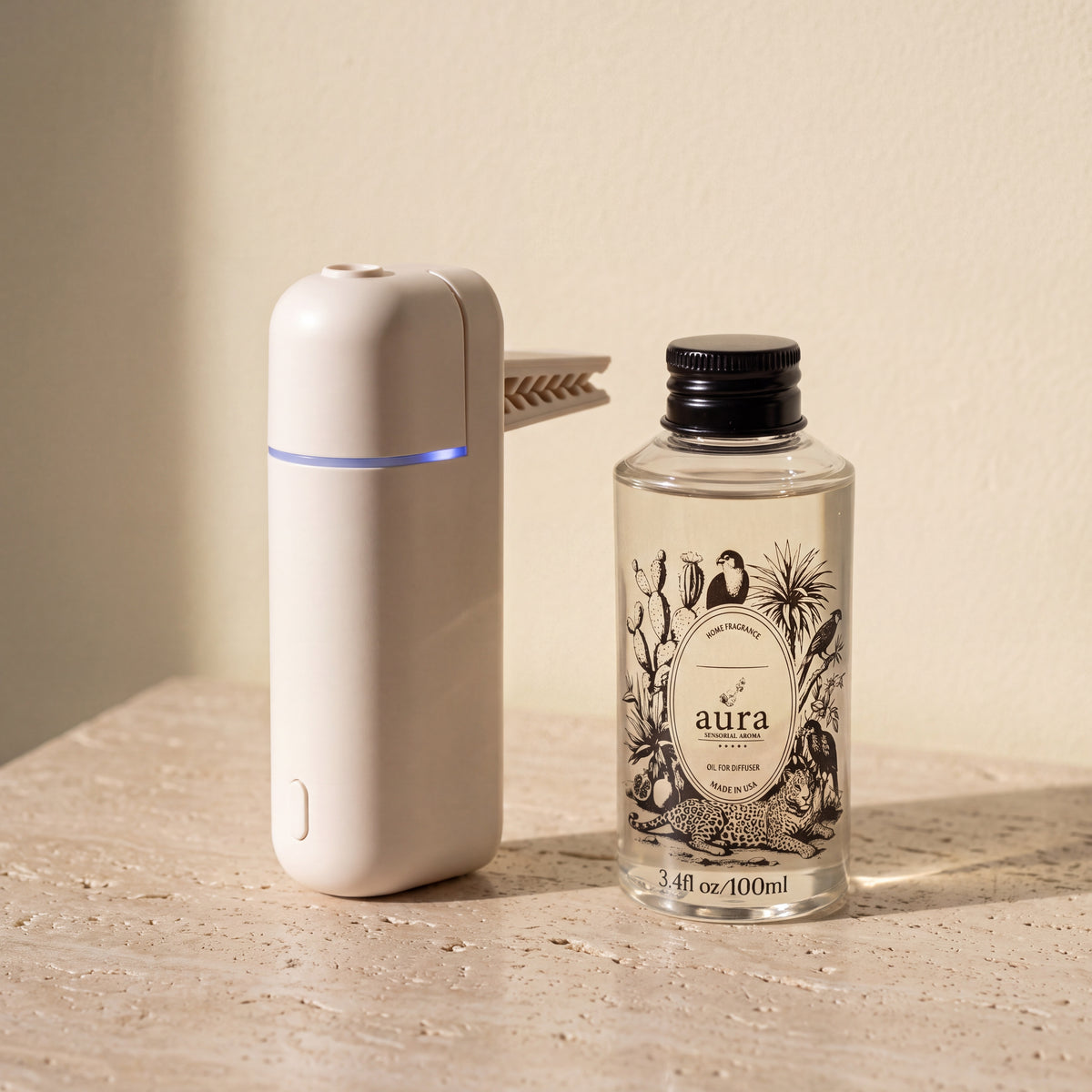 White AURA Strada beside the 100 ml Aura fragrance oil bottle